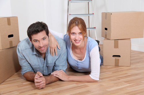 Movers transporting boxes and furniture through a local Hatch End street