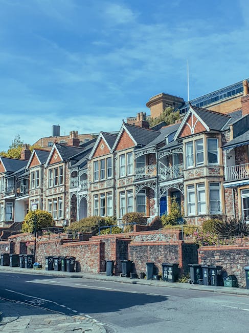 An aerial view of a residential street in Hatch End showing a row of semi-detached brick houses with varied roof styles, including tiled and flat roofs. In the foreground, a driveway area features sev